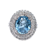 18kt white gold blue topaz ring with a double halo of diamonds 